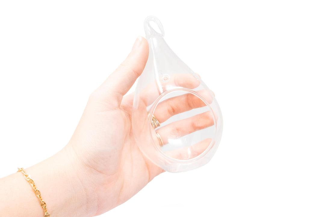 hand holding a glass teardrop terrarium