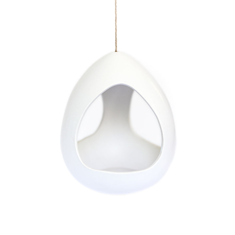 large white ceramic pod hanging by hemp string