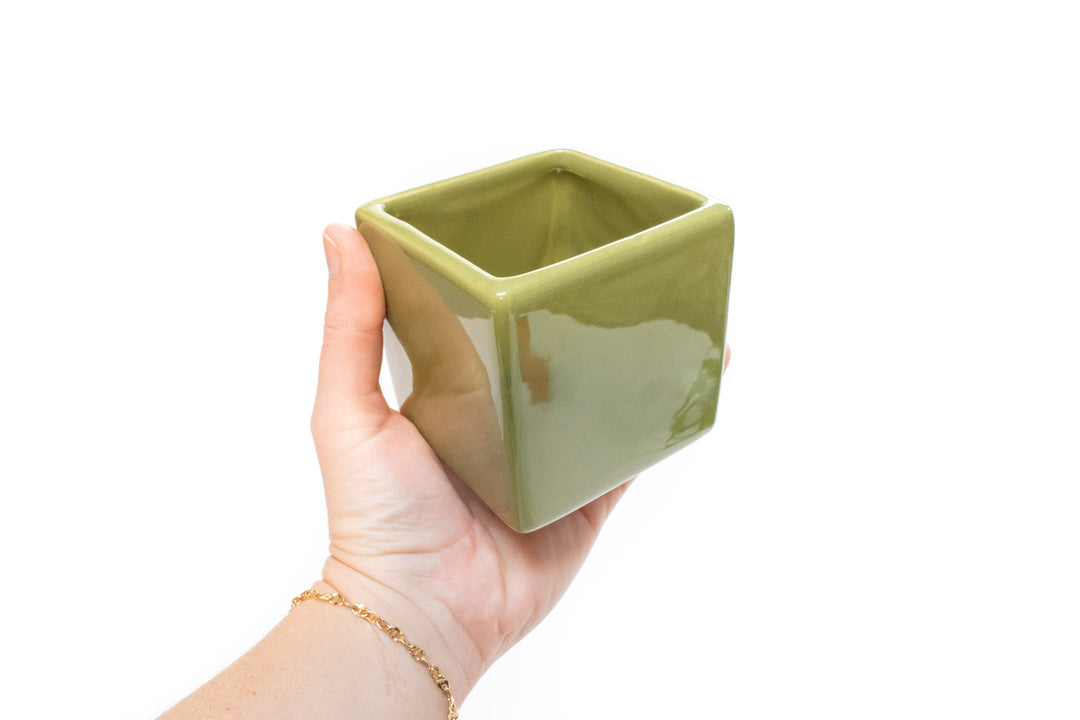 hand holding green ceramic cube planter