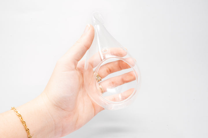 hand holding a teardrop shaped glass terrarium